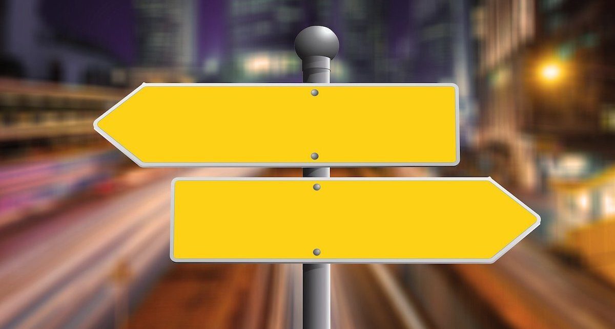 Two yellow signs pointing in opposite directions