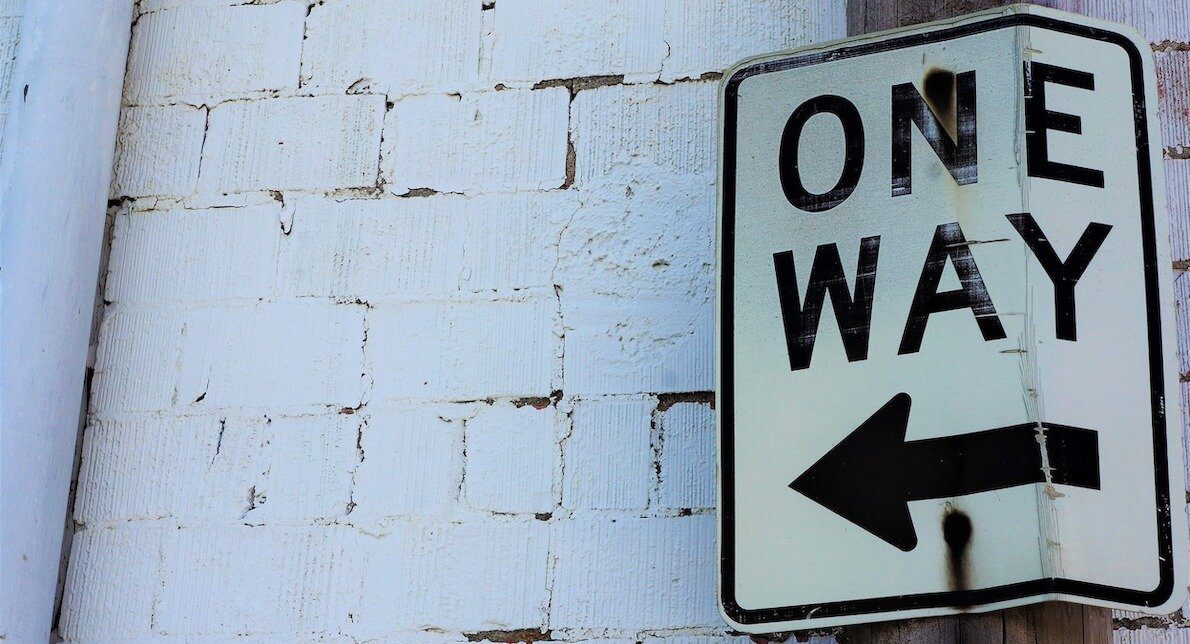 A street sign that reads “One Way” with an arrow pointing left